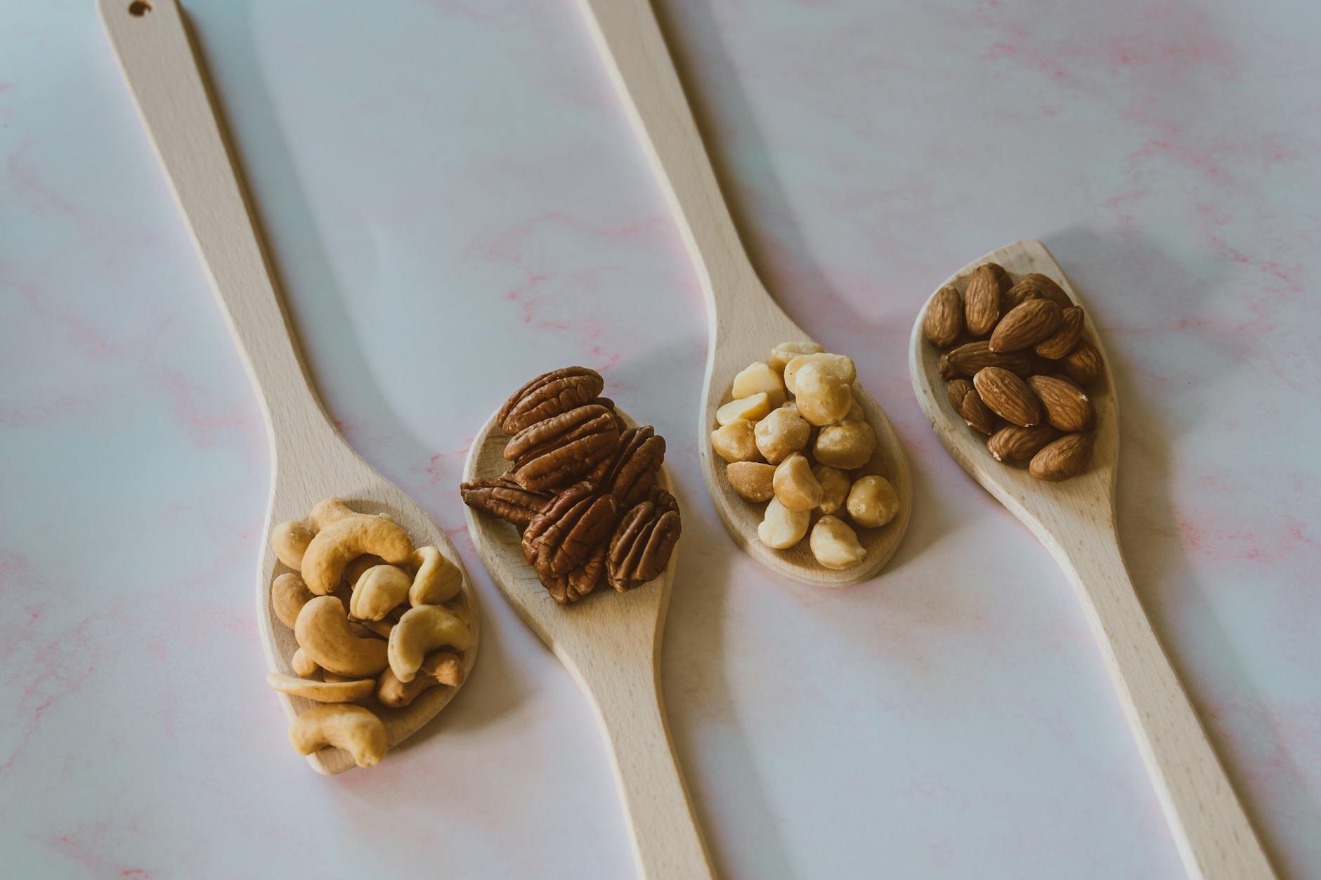 close up shot of assorted nuts on a wooden spoon